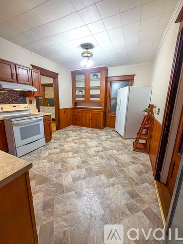 A kitchen with wooden cabinets and a checkered floor.