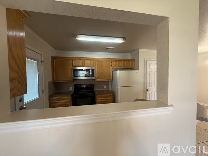 A kitchen with wooden cabinets and appliances.