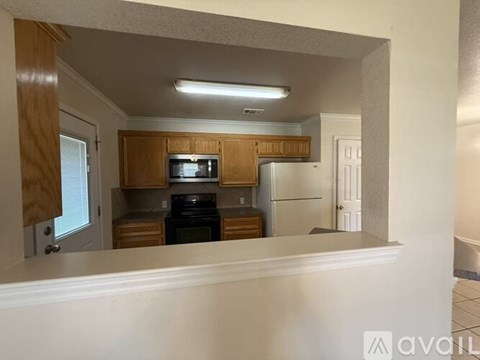 A kitchen with wooden cabinets and appliances.