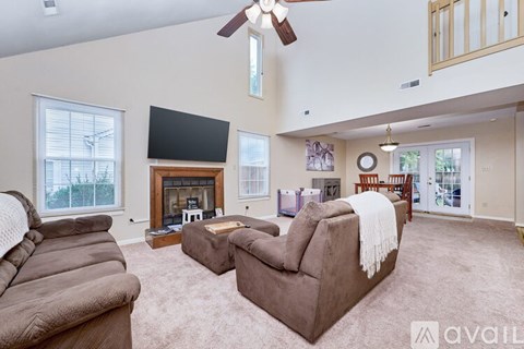 A living room with a brown couch and a fireplace.