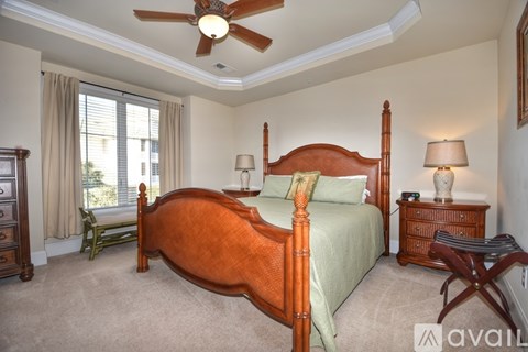 A bedroom with a large bed and a ceiling fan.