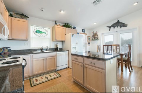 A kitchen with wooden cabinets and a black countertop.