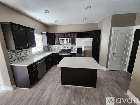 A modern kitchen with dark wood cabinets and a white island.