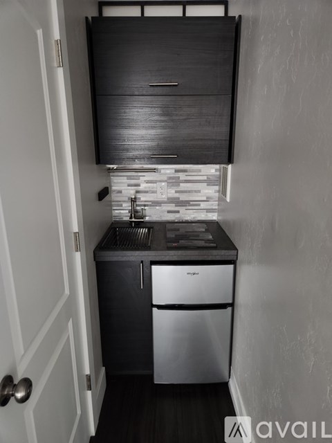 A kitchen with a stainless steel dishwasher and a black cabinet above it.