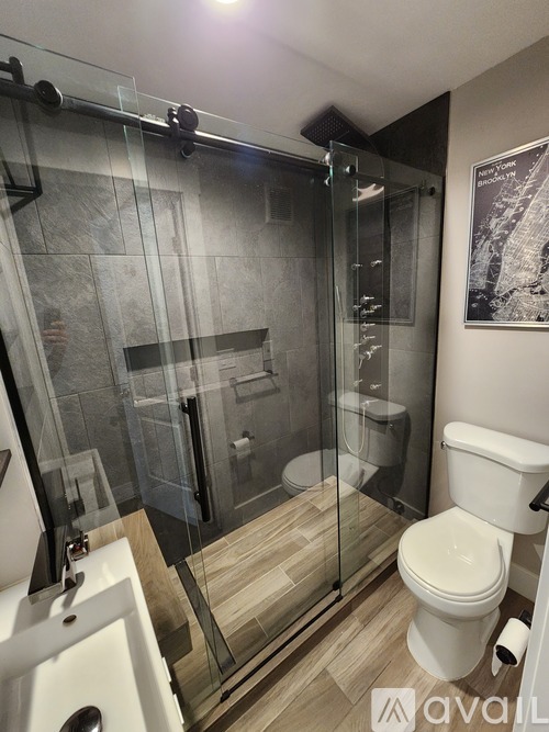 A modern bathroom with a glass shower enclosure and a white toilet.