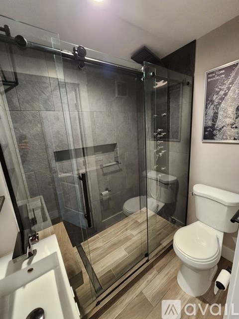A modern bathroom with a glass shower enclosure and a white toilet.