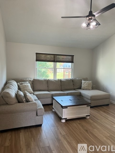 A living room with a large sectional sofa and a coffee table.