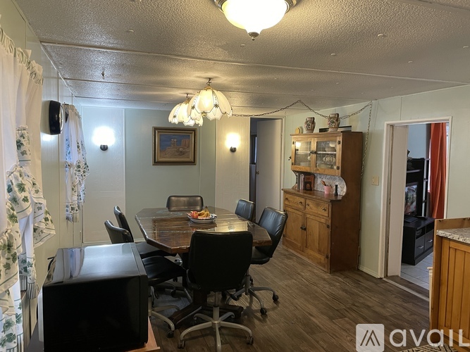 A dining room with a wooden table and chairs.