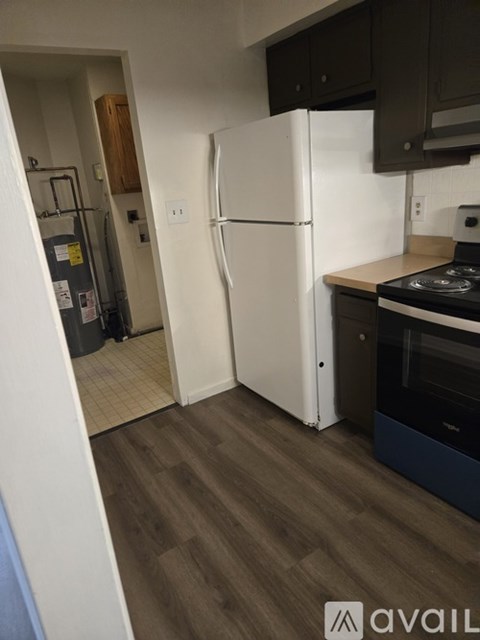 A kitchen with a white fridge and a black stove.
