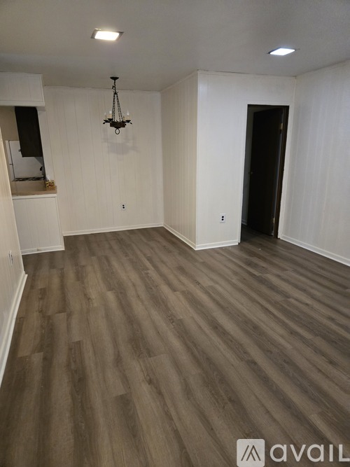 A room with wooden flooring and a chandelier.
