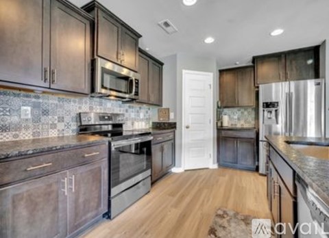 A kitchen with dark wood cabinets and a white door in the background.