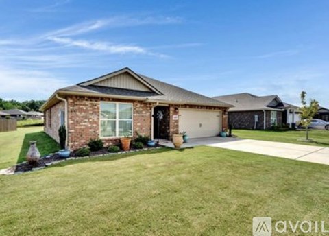 A house with a brown brick exterior and a large front yard is for sale.