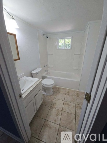 A small bathroom with a toilet, sink and mirror.