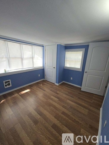 A room with wooden flooring and white walls.