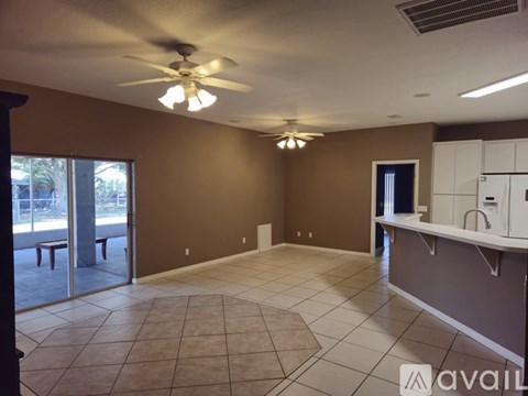 A spacious room with a ceiling fan and tiled flooring.