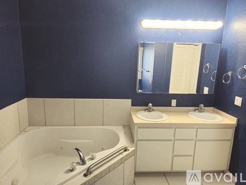 A white bathroom sink with a white bathtub and a mirror above it.
