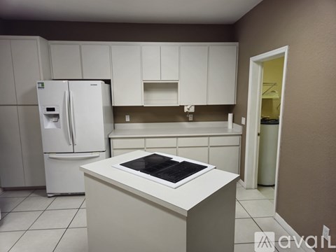 A kitchen with white cabinets and a white fridge.