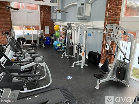 A gym with treadmills, weights, and exercise balls.