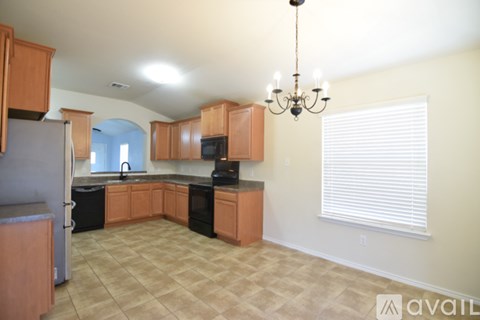 A kitchen with wooden cabinets and a chandelier.