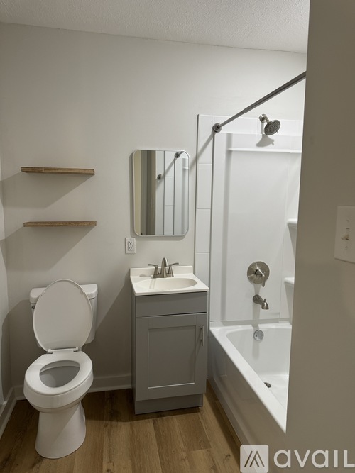 A bathroom with a toilet, sink, and a shower.