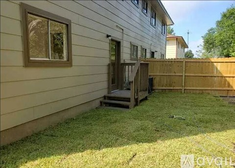 A house with a wooden fence and a small deck.