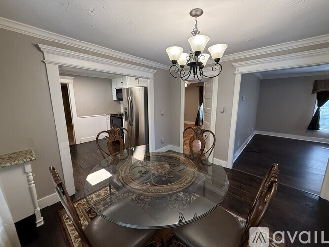 A dining room with a glass table and chairs.