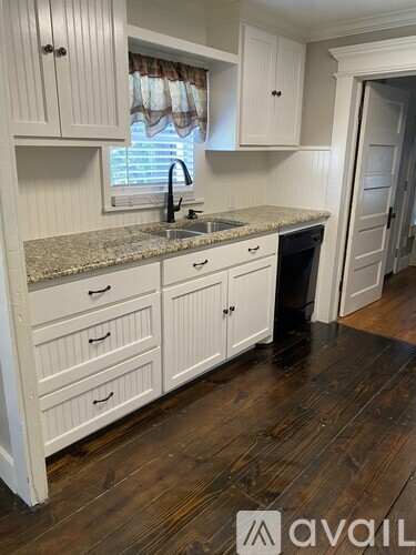 A kitchen with white cabinets and a granite countertop.