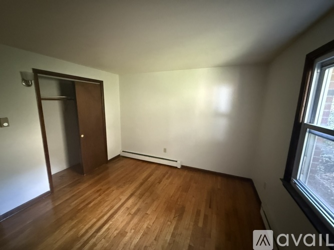 A room with wooden floors and a window showing a snowy scene outside.