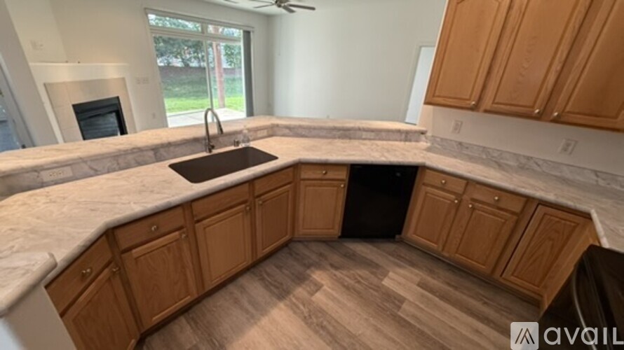 A kitchen with wooden cabinets and a marble countertop.