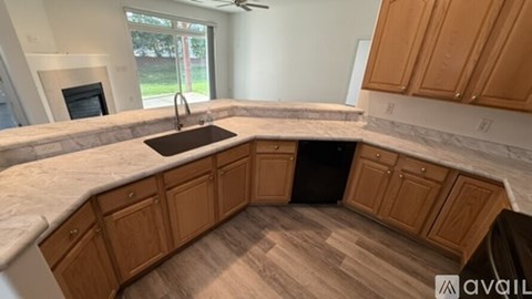A kitchen with wooden cabinets and a marble countertop.