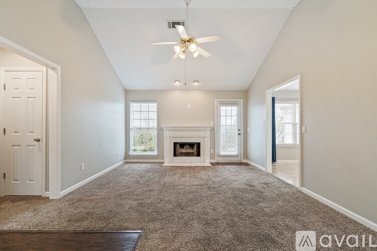 A living room with a fireplace and a ceiling fan.