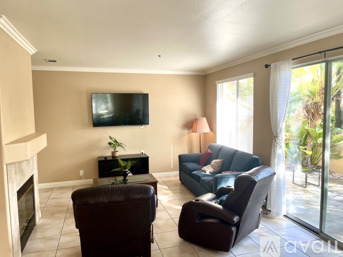 A living room with a fireplace, a couch, a chair, and a television.