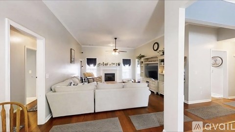 A living room with a white couch and a fireplace.