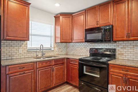A kitchen with wooden cabinets and a black oven.