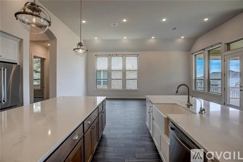 A modern kitchen with a long countertop and a sink.