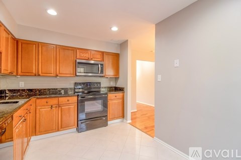 A kitchen with wooden cabinets and a microwave above the stove.