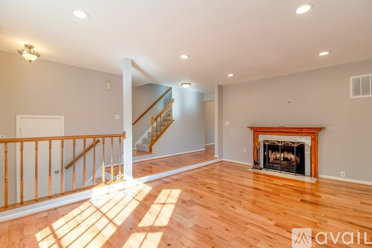 A spacious living room with a fireplace and a staircase.