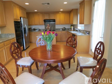 A kitchen with a table and chairs.