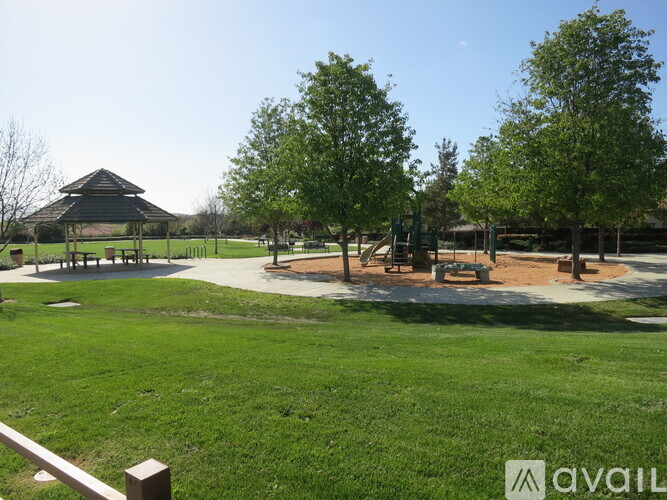 A park with a gazebo, trees, and a playground.