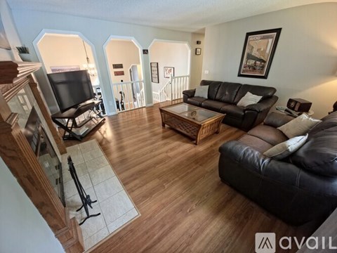 A living room with a black leather couch and a wooden coffee table.