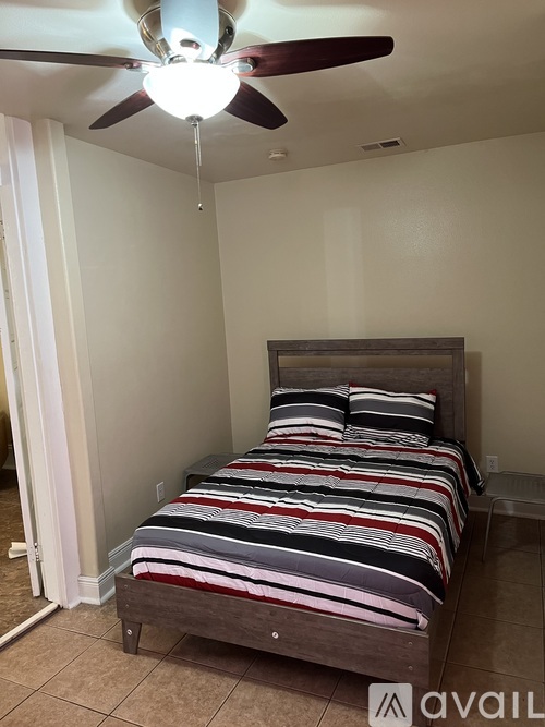 A bedroom with a bed and a ceiling fan.