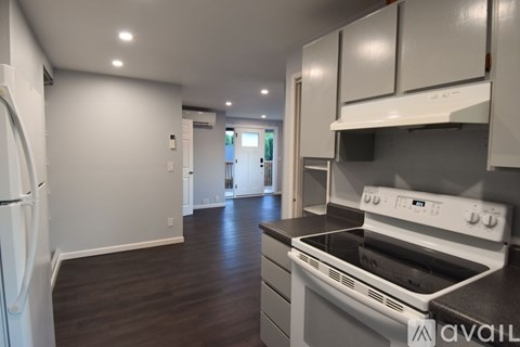 A kitchen with white cabinets and a stove top oven.