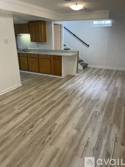 A room with wooden flooring and a staircase.