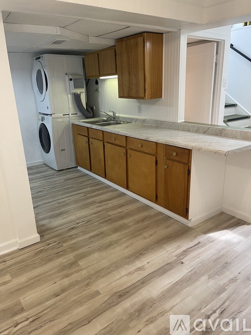A kitchen with wooden cabinets and a washing machine.