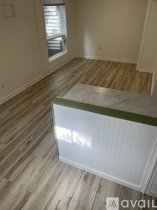 A room with wooden flooring and a window.