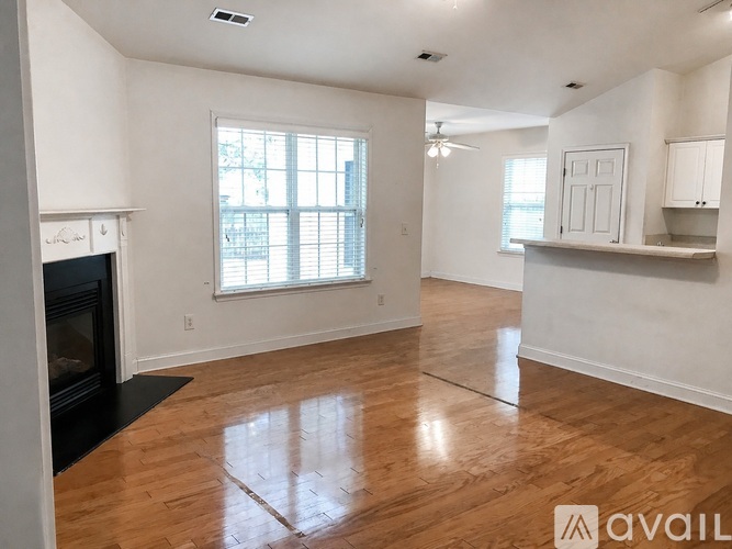 A spacious living room with hardwood floors and a fireplace.