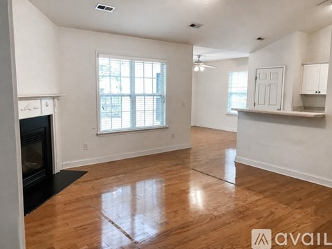 A spacious living room with hardwood floors and a fireplace.