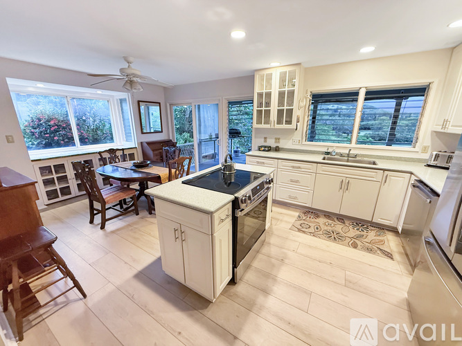 A kitchen with a white island and wooden floors.