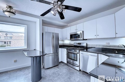 A modern kitchen with stainless steel appliances and white cabinets.