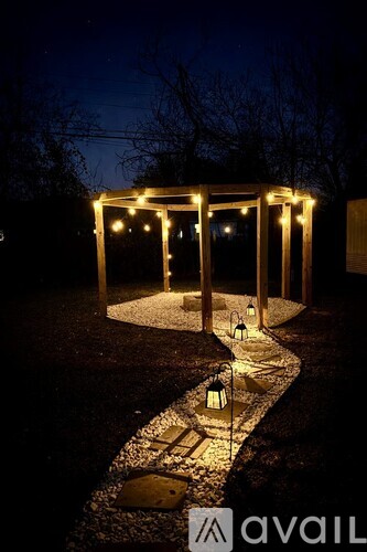 A pathway with lights and lanterns leading to a gazebo.
